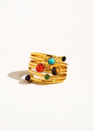 Gold ring with multicolored stones on a white background