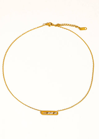 Gold necklace with a small rectangular pendant on a white background