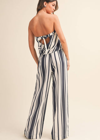 Woman wearing a striped jumpsuit on a beige background