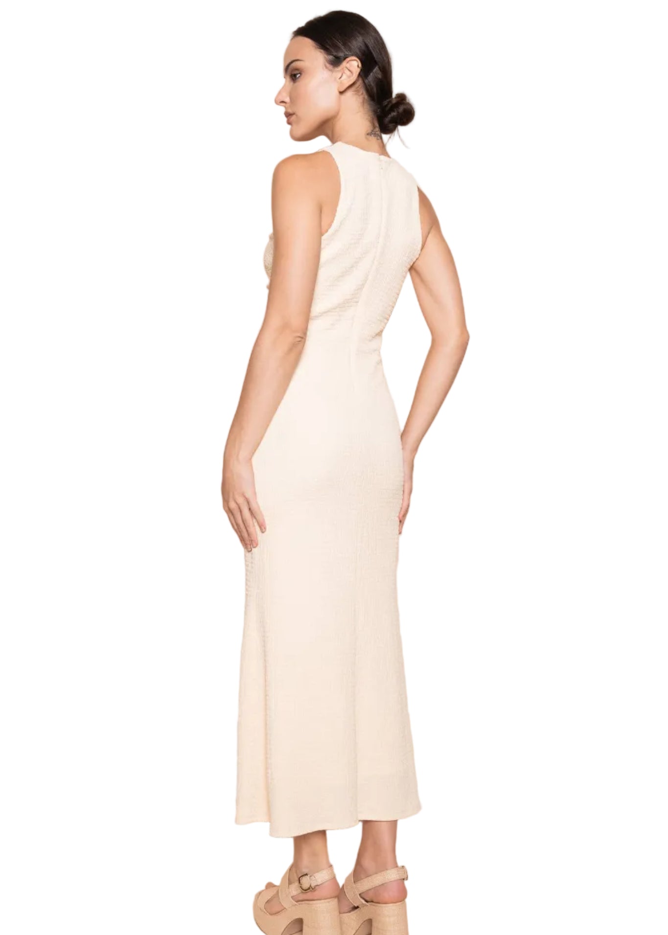 Woman wearing a white dress against a beige background