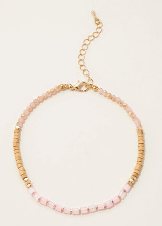 Necklace with pink and gold beads on a light beige background