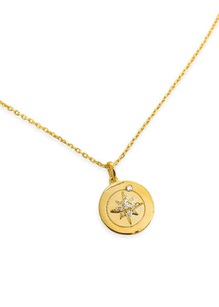 Gold necklace with a round pendant featuring a star design on a white background