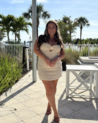 women in cream crochet dress with tropical background