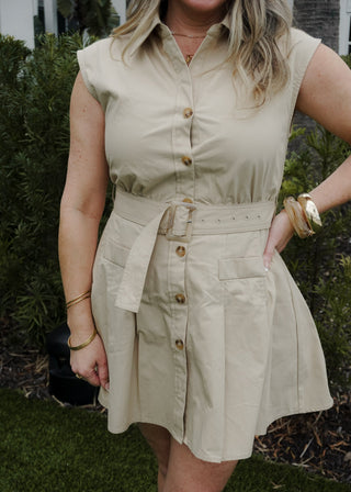 Woman wearing a beige sleeveless dress with buttons in an outdoor setting