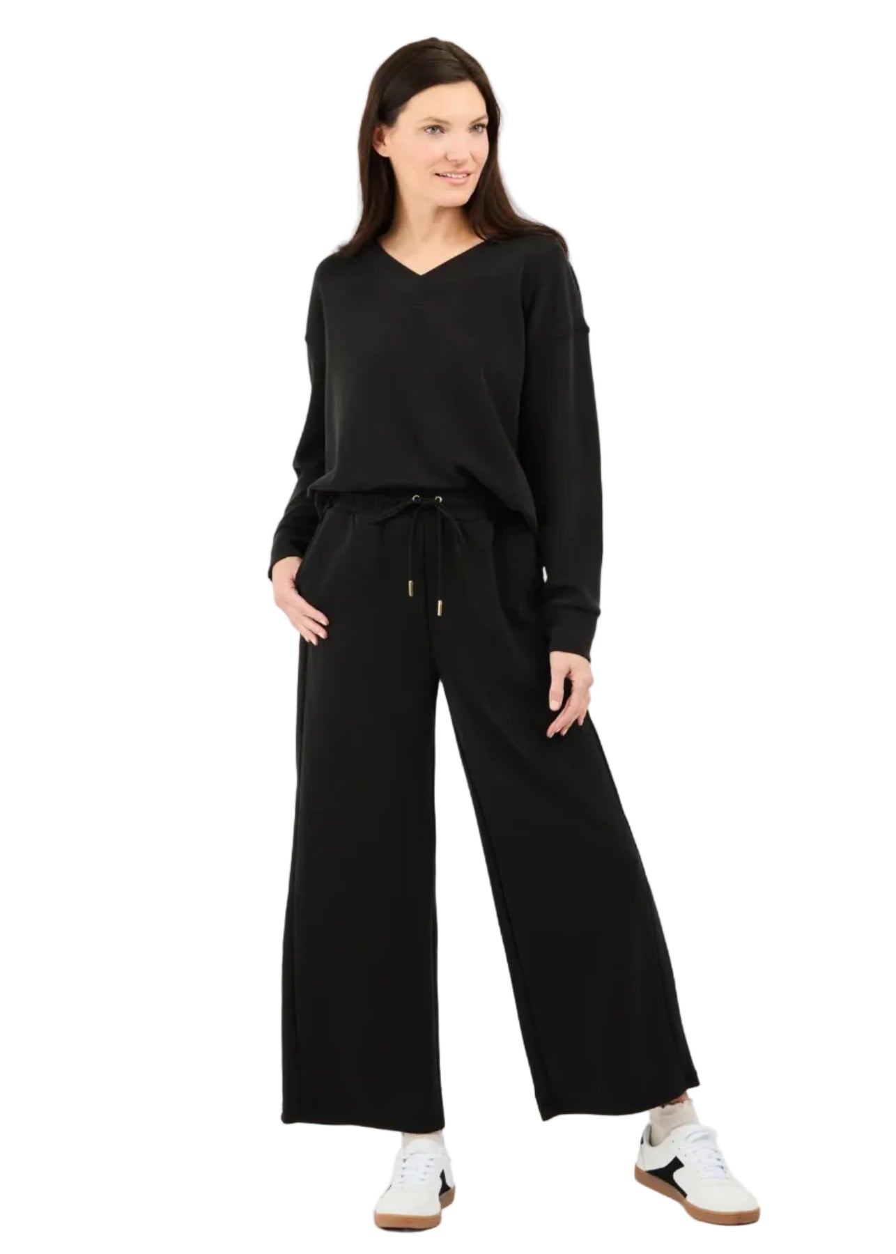 Woman wearing a black outfit with wide-leg pants on a white background