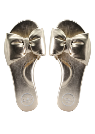 Pair of metallic sandals with large bows on a white background