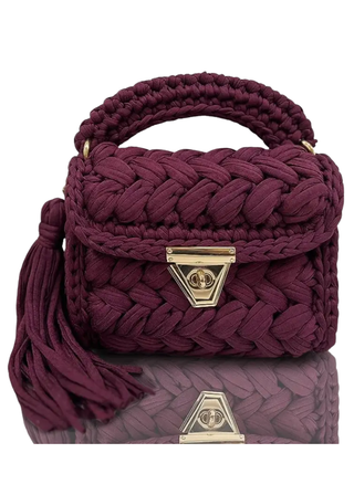 Woven purple handbag with gold accents on a white background