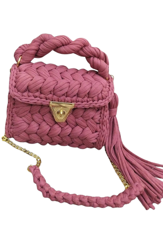Pink braided handbag with a gold chain on a white background