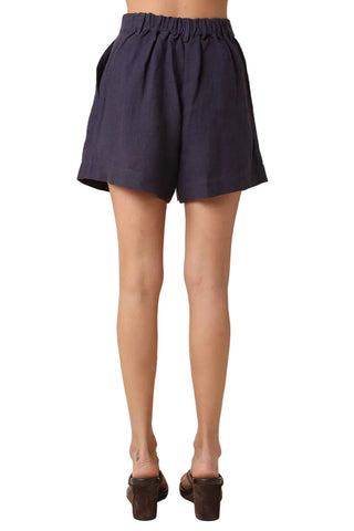 Navy blue shorts worn by a person on a beige background