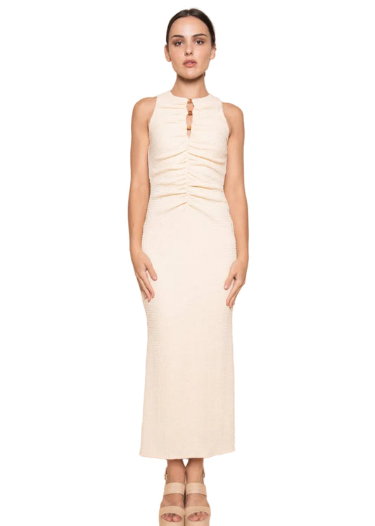 Woman wearing a cream sleeveless dress against a beige background