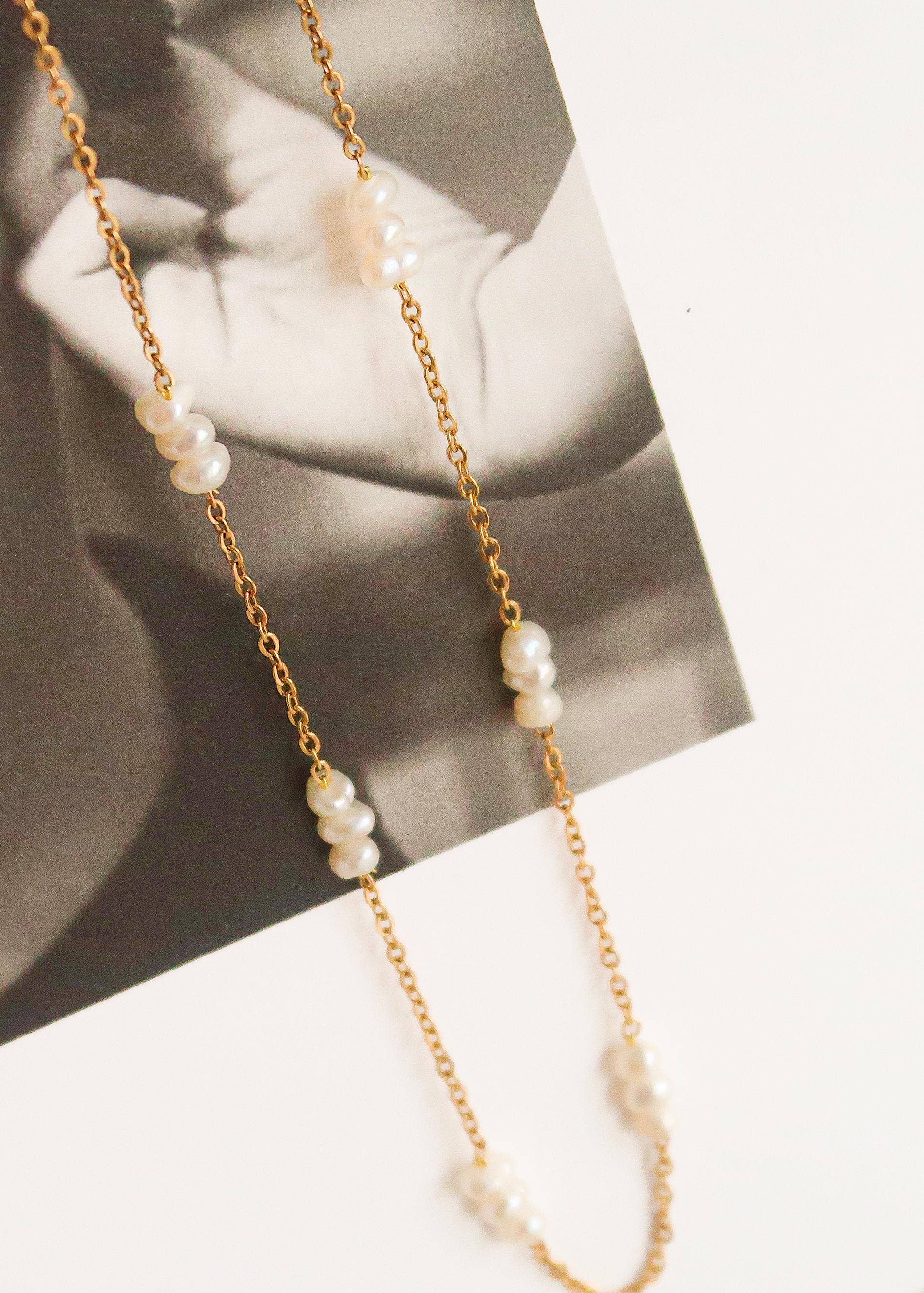 Gold chain necklace with pearls on a blurred background