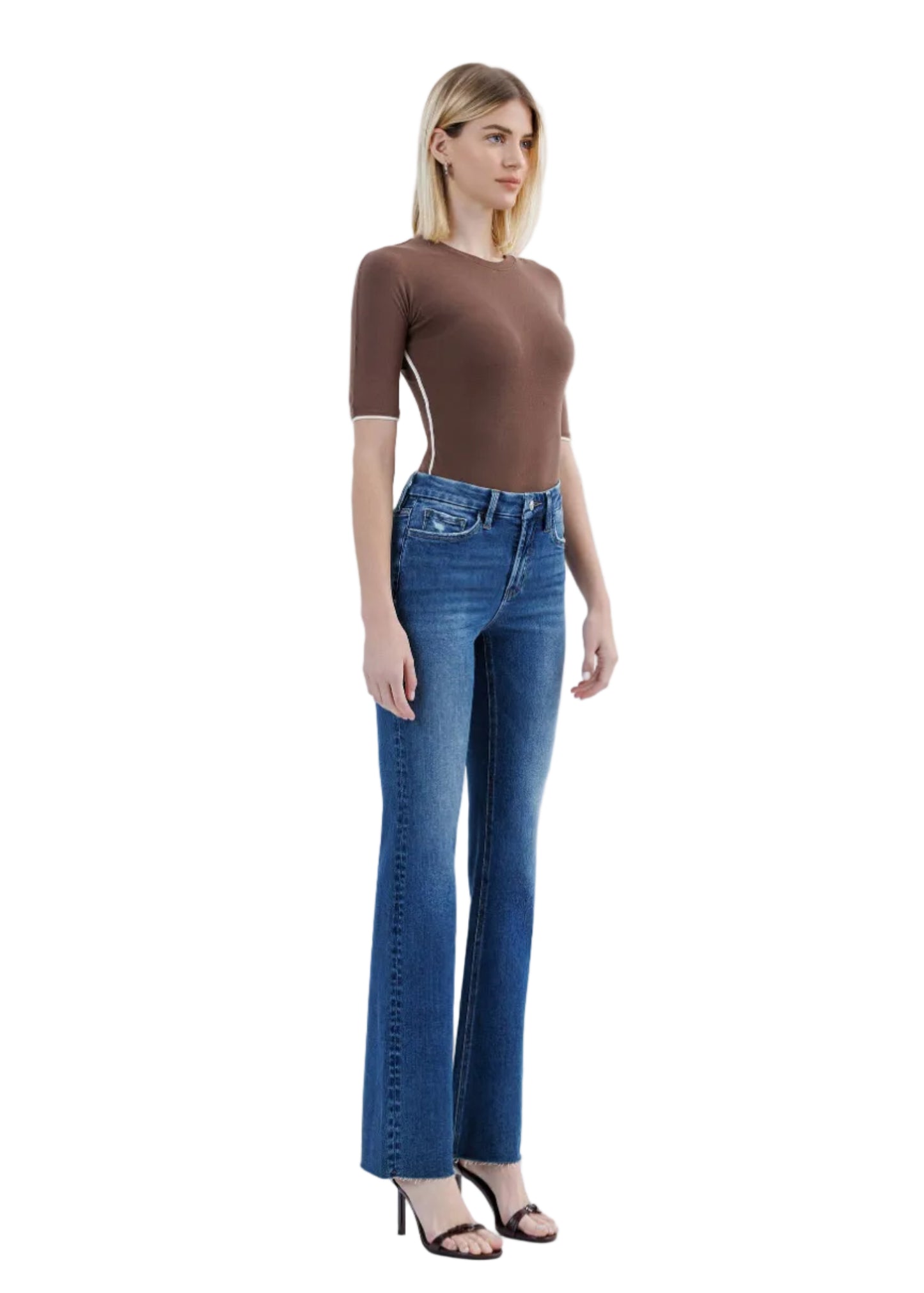 Woman wearing a brown top and blue jeans on a white background