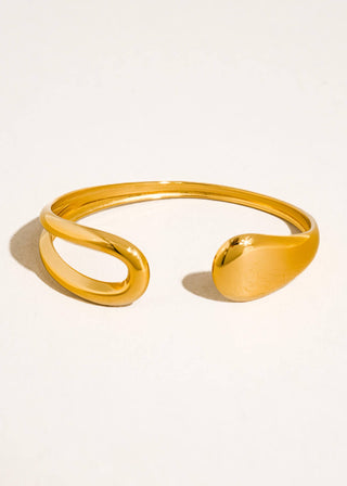 Gold bracelet on a light beige background
