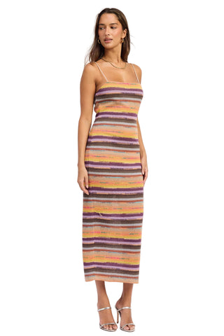 Woman wearing a colorful striped dress on a white background