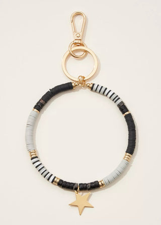 Beaded keychain with star charm on a beige background