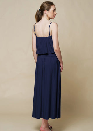 Woman wearing a navy blue dress against a beige background