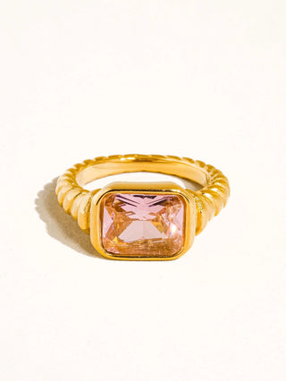 Gold ring with a pink gemstone on a white background