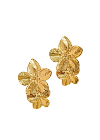 A person wearing a gold-colored floral earring