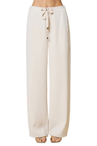 Beige wide-leg pants with a drawstring waist on a beige background
