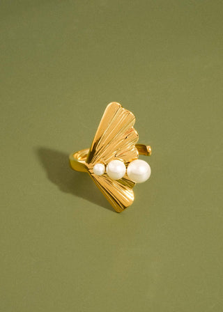 Gold ring with pearls on a green background