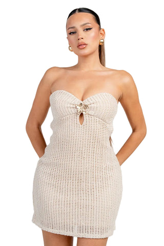 Woman wearing a beige strapless dress against a white background
