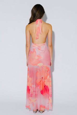 Woman wearing a pink floral dress against a white background