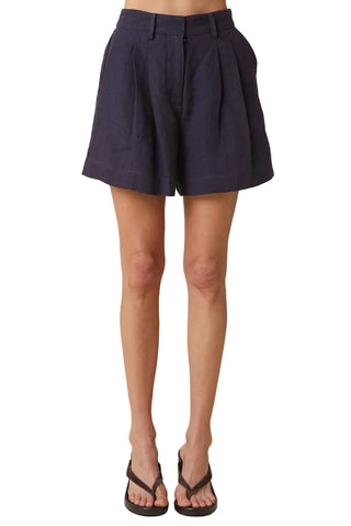 Navy shorts worn by a person on a beige background