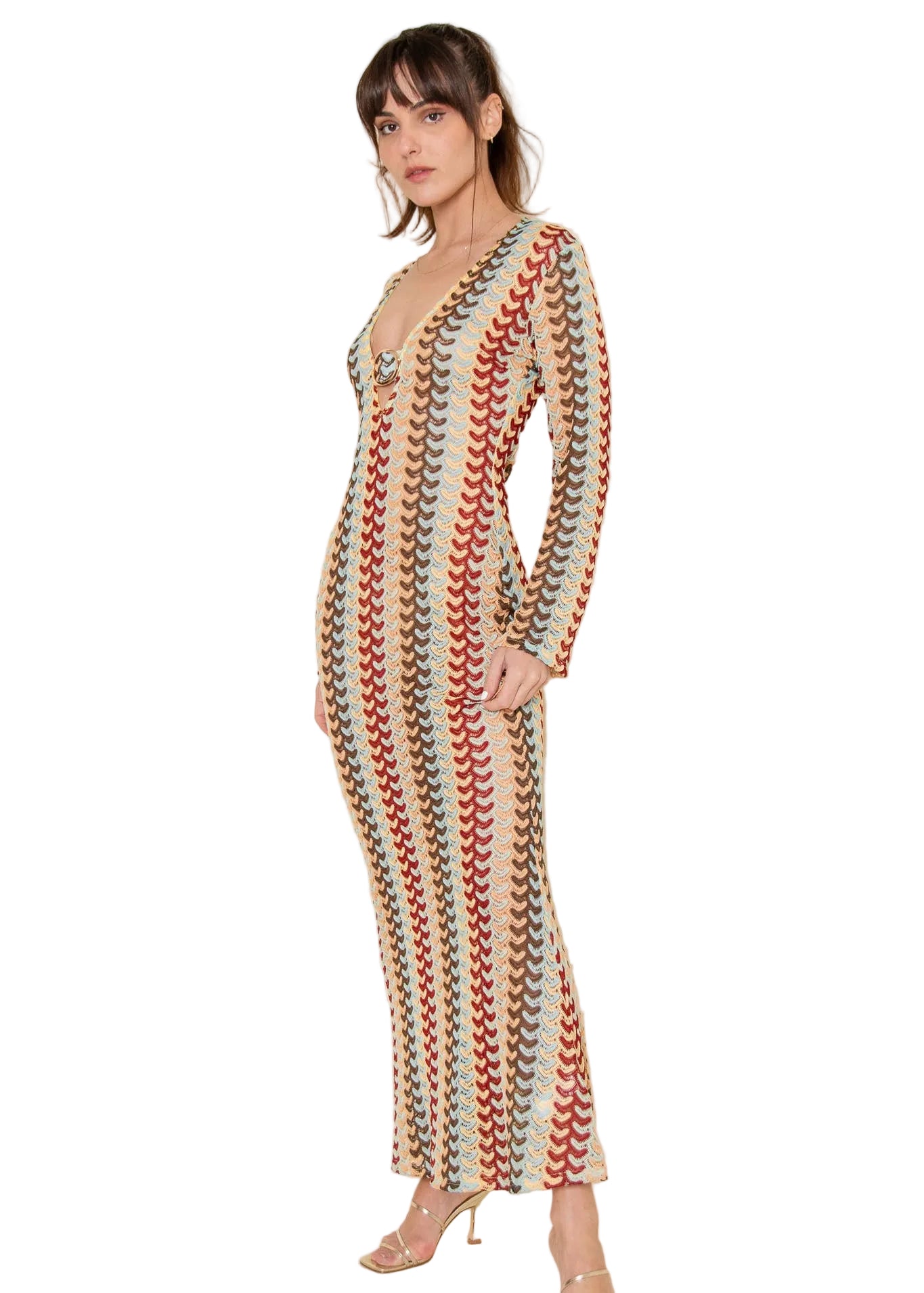 Woman wearing a long-sleeve, patterned resort coverup pucci style dress against a plain background