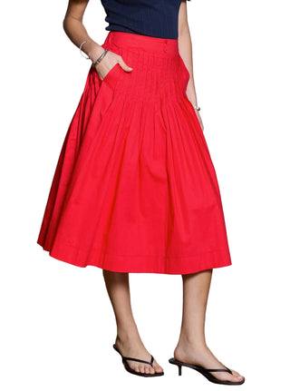 Person wearing a red skirt with a neutral background