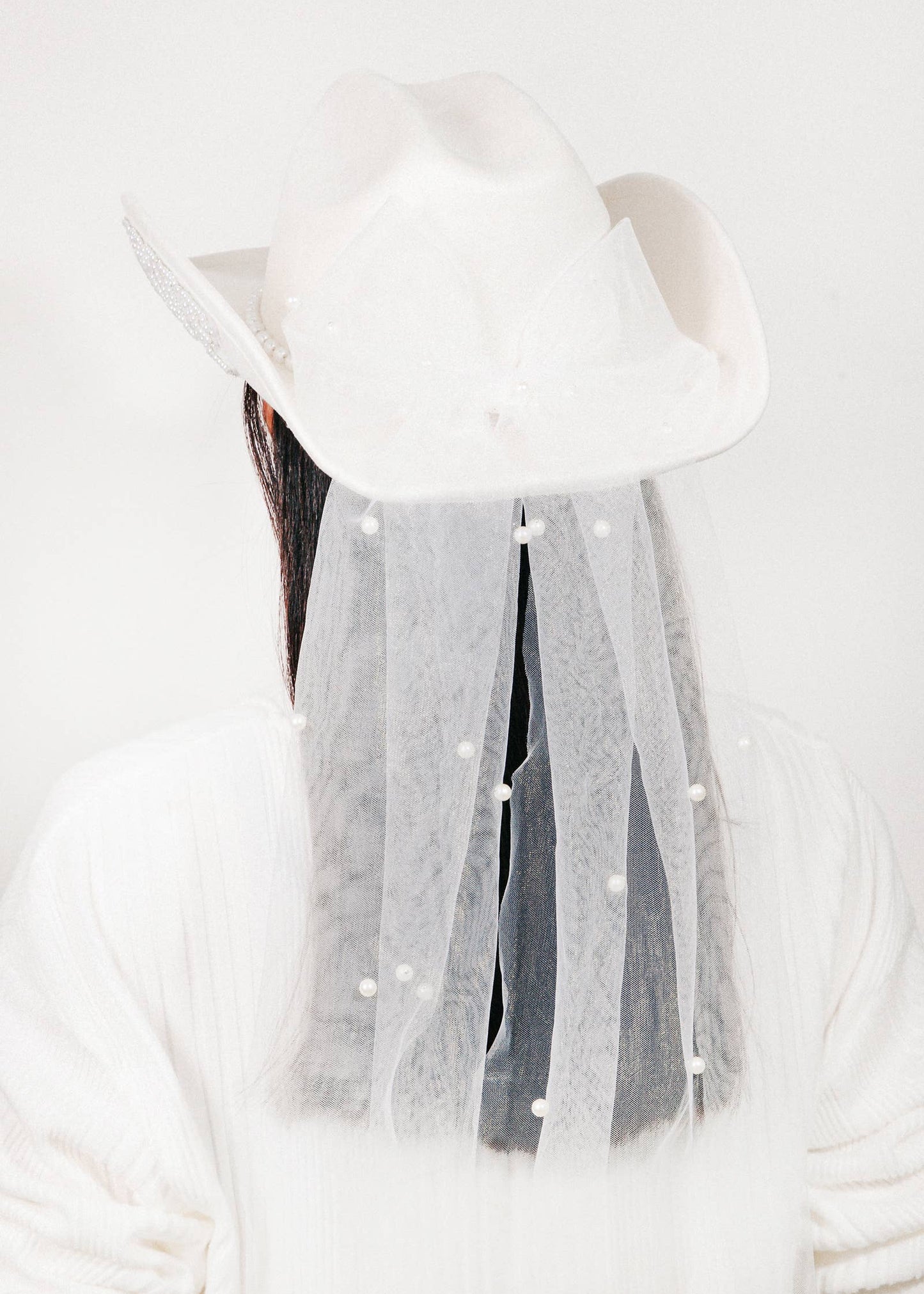 White hat with tassels on a white background