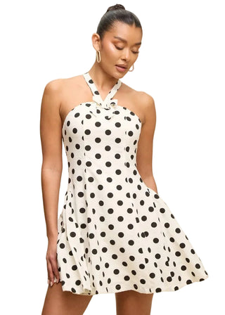 Woman wearing a polka dot dress against a beige background