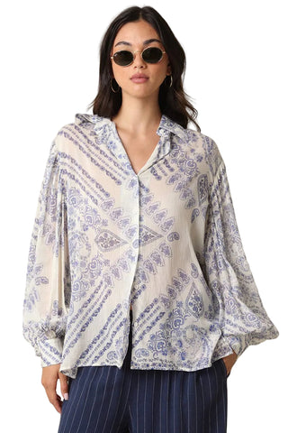 Woman wearing a patterned blouse with a beige background