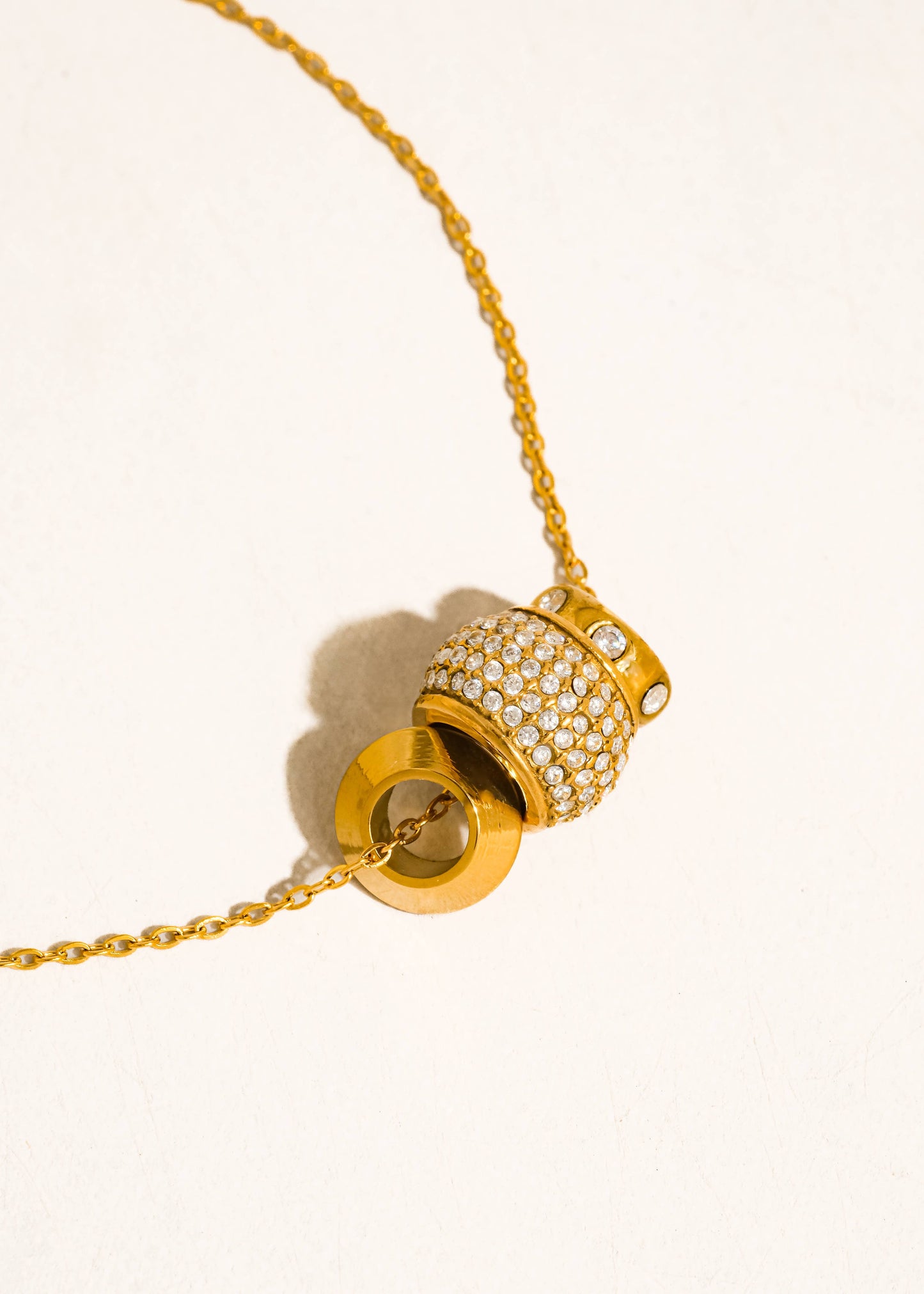 Gold necklace with a detailed pendant on a white background