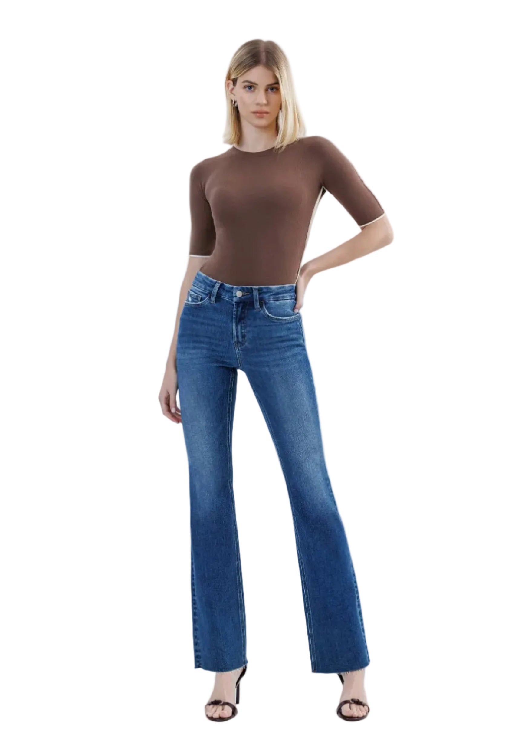 Woman wearing a brown top and blue jeans on a white background