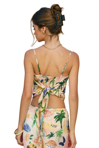 Woman wearing a colorful floral dress with a beige background