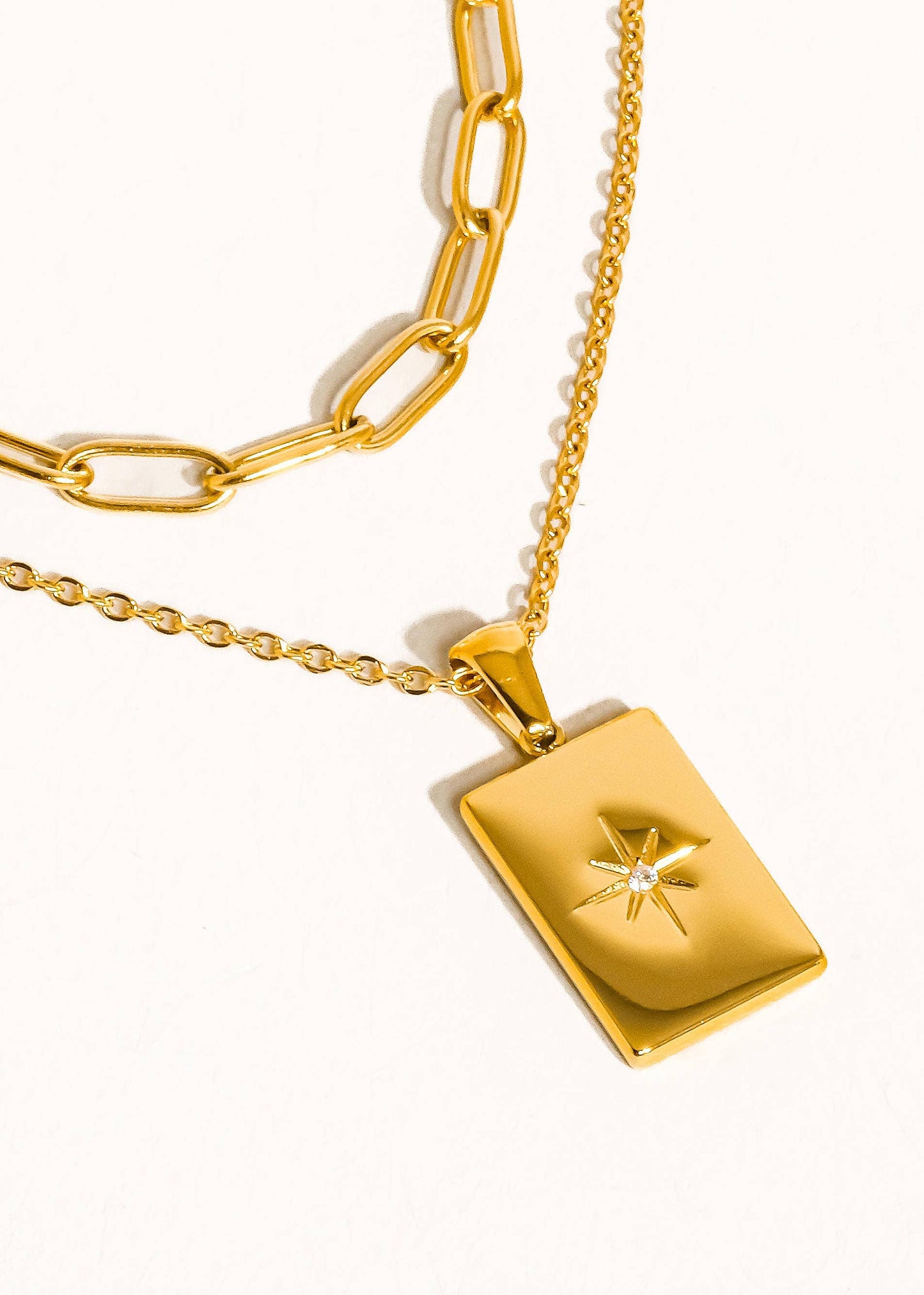 Gold necklace with a pendant on a white background