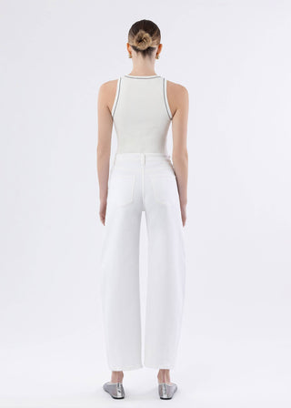 Person wearing a white sleeveless top and wide-leg pants on a plain background