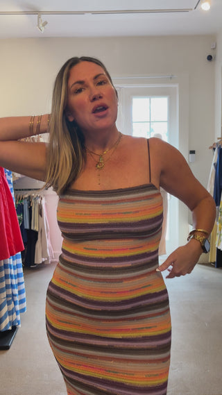 video of striped dress on women with store in background