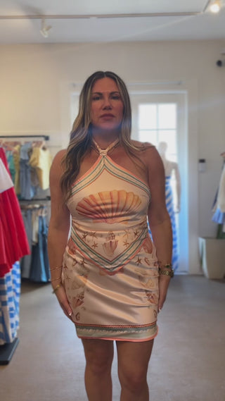 woman trying on shell print satin dress