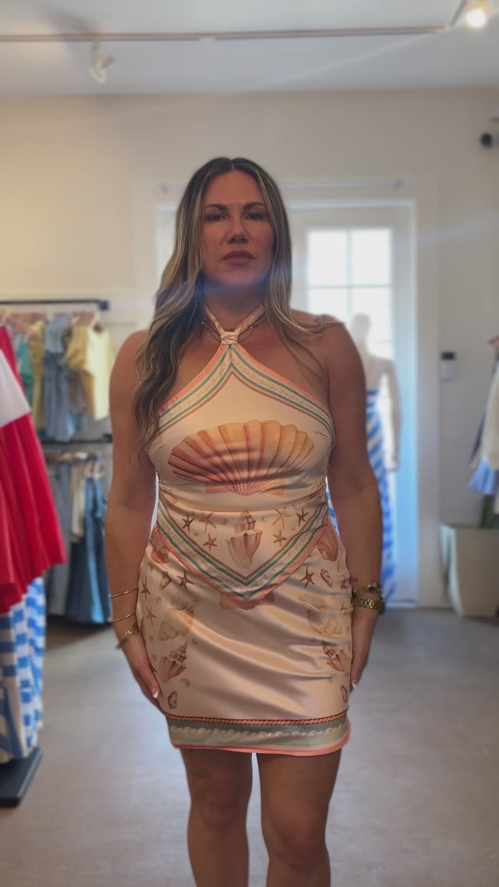 woman trying on shell print satin dress